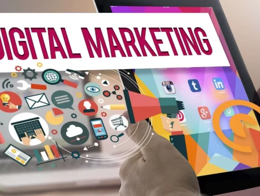 A photo of a person holding a tablet with the words "Digital Marketing" on the screen.